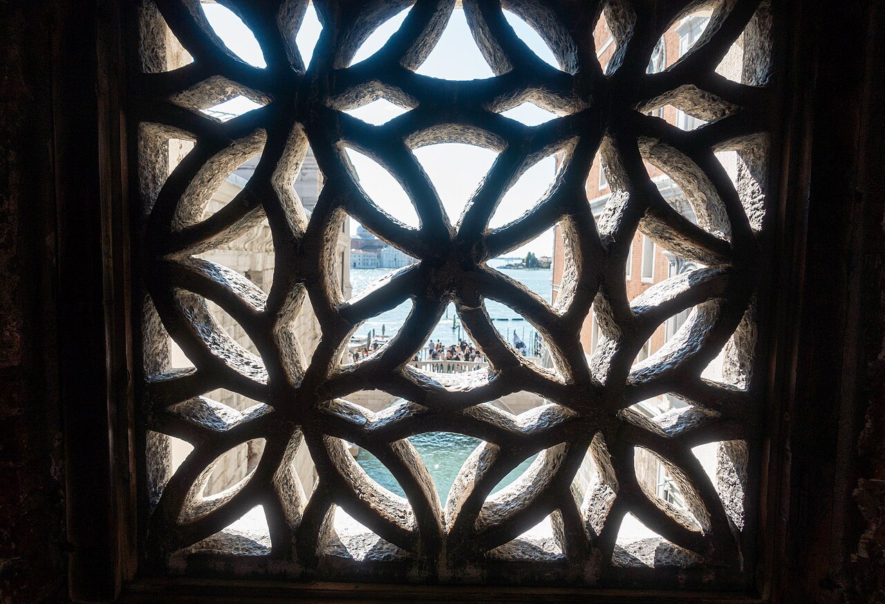 Looking out through the stone screen of a window in the Bridge of Sighs