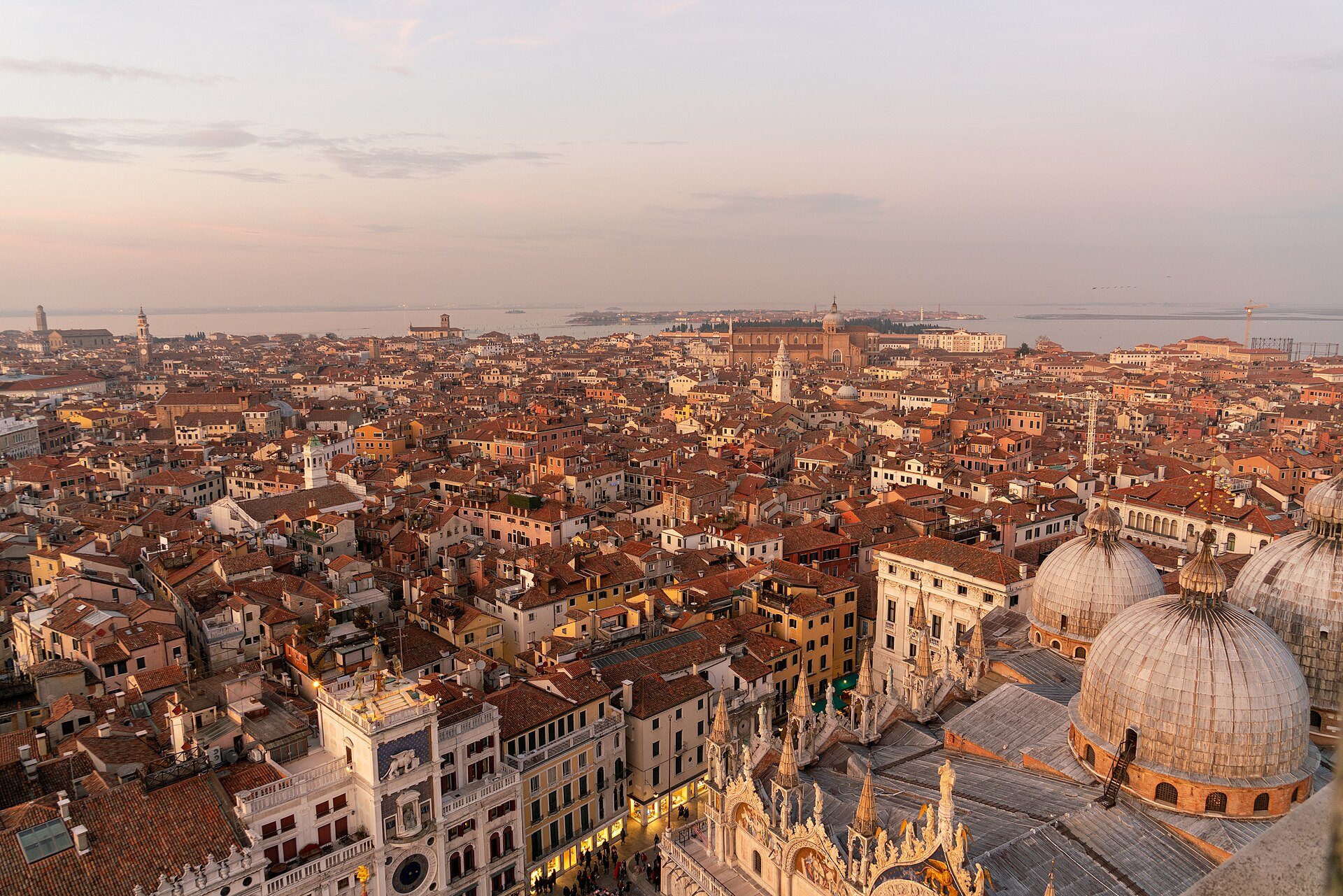 The rooftops of Venice at sunset, St Mark's domes and the Clock Tower in the corner