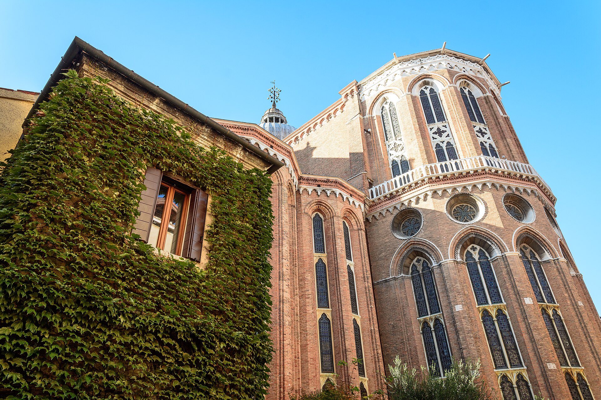 The Gothic apse of Santi Giovanni e Paolo beside an ivy-covered wall