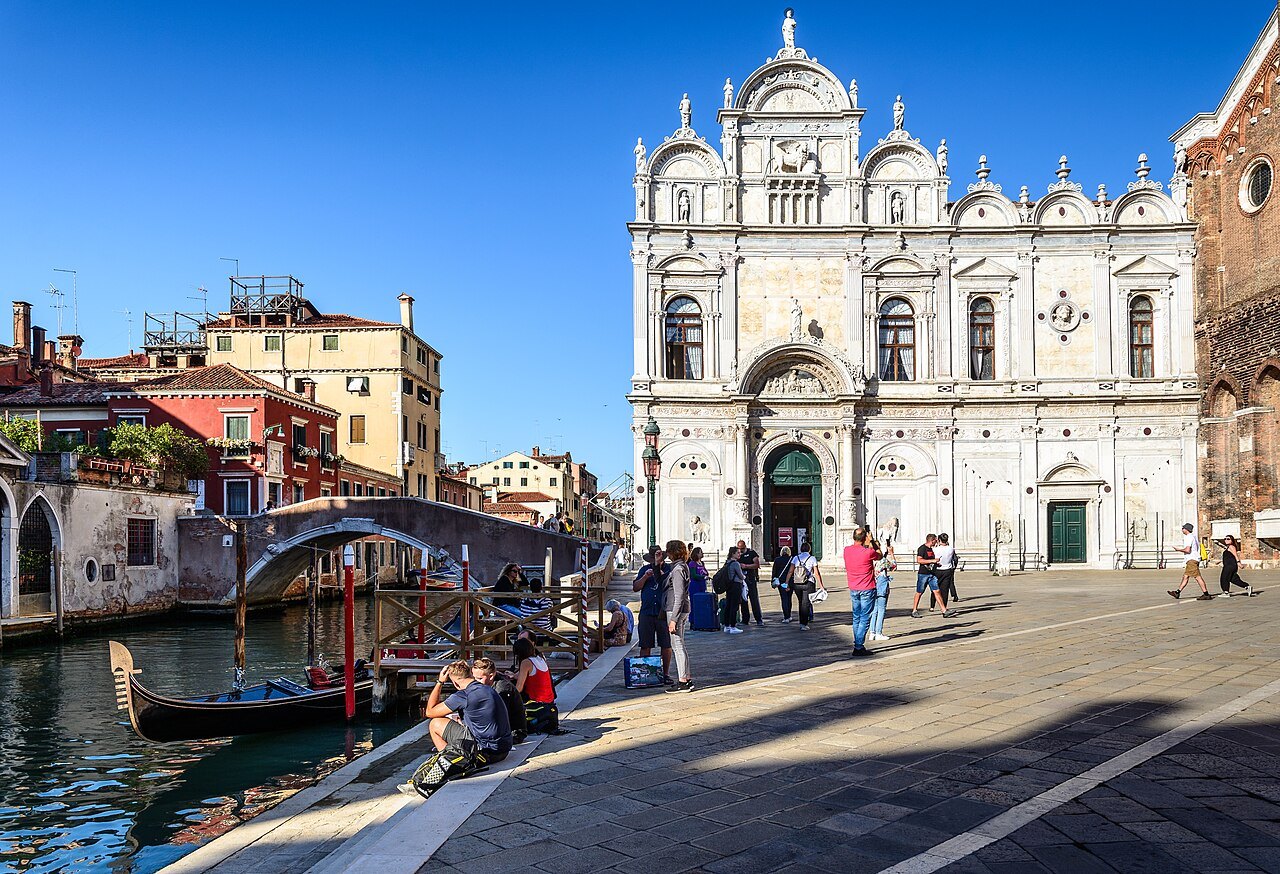 The marble front of the Scuola Grande di San Marco beside its canal