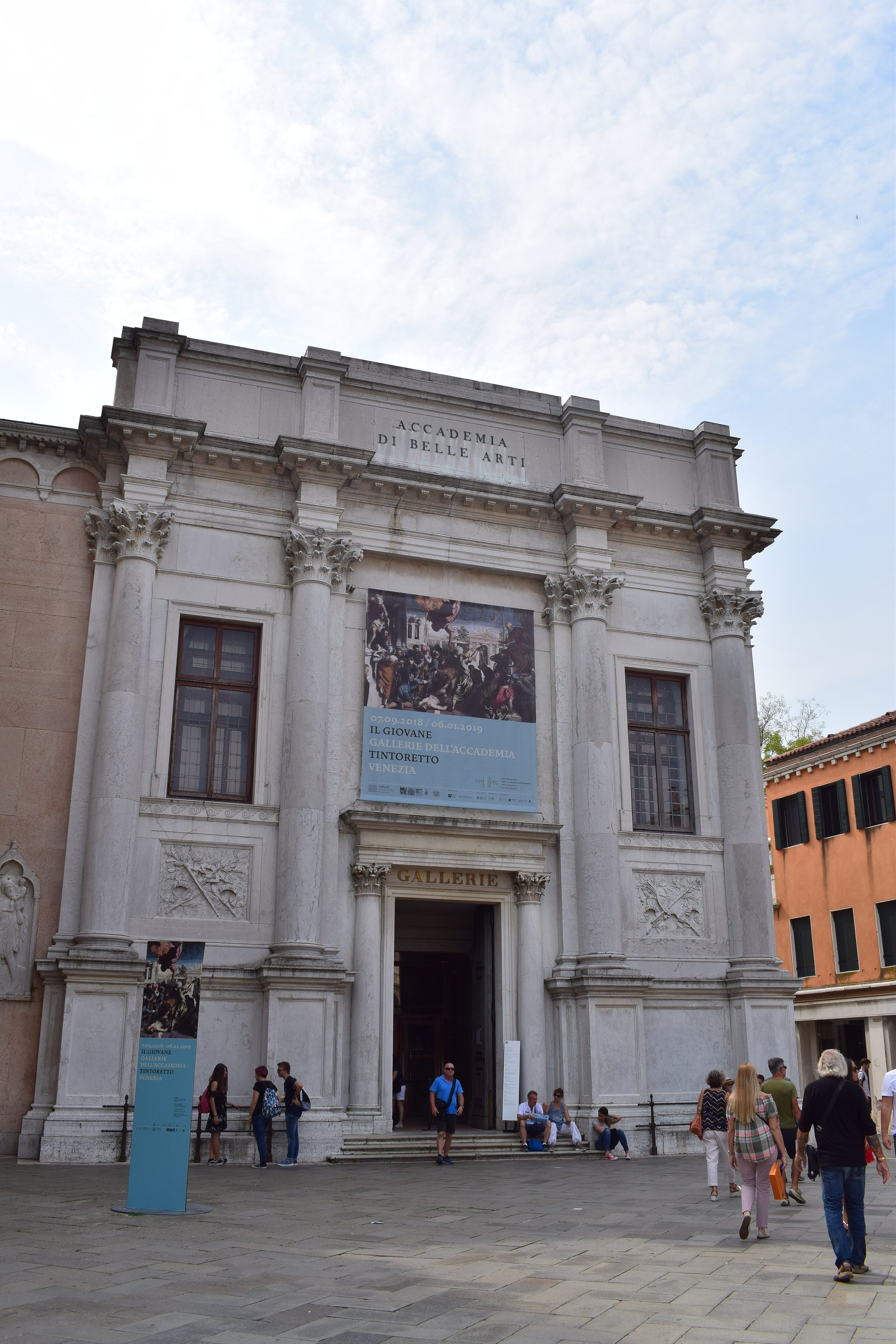 The front of the Gallerie dell'Accademia, a plain white façade with a banner hung across it