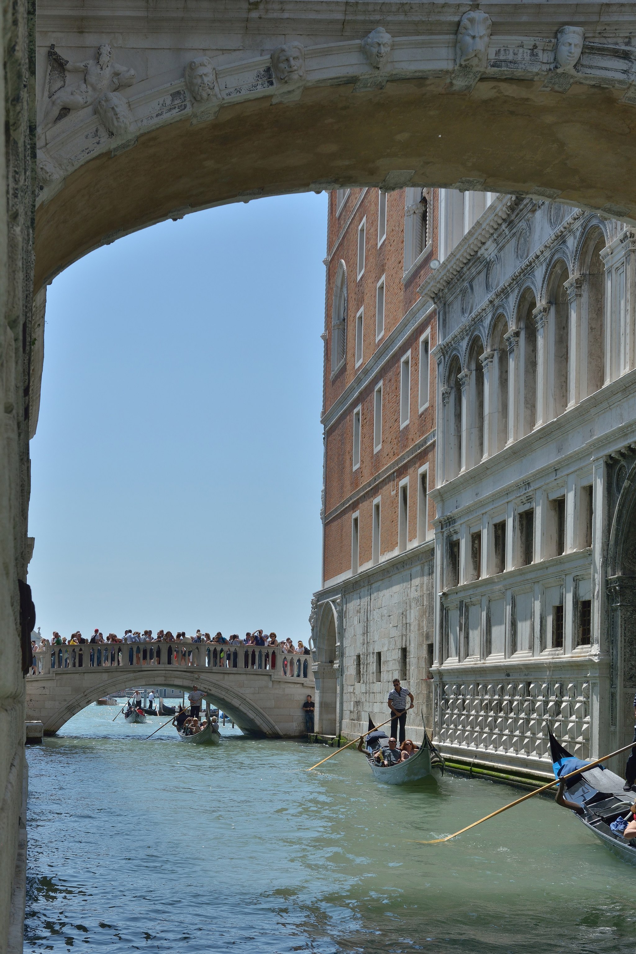 Gondolas moored on the narrow canal behind the Doge's Palace, the Bridge of Sighs crossing above them