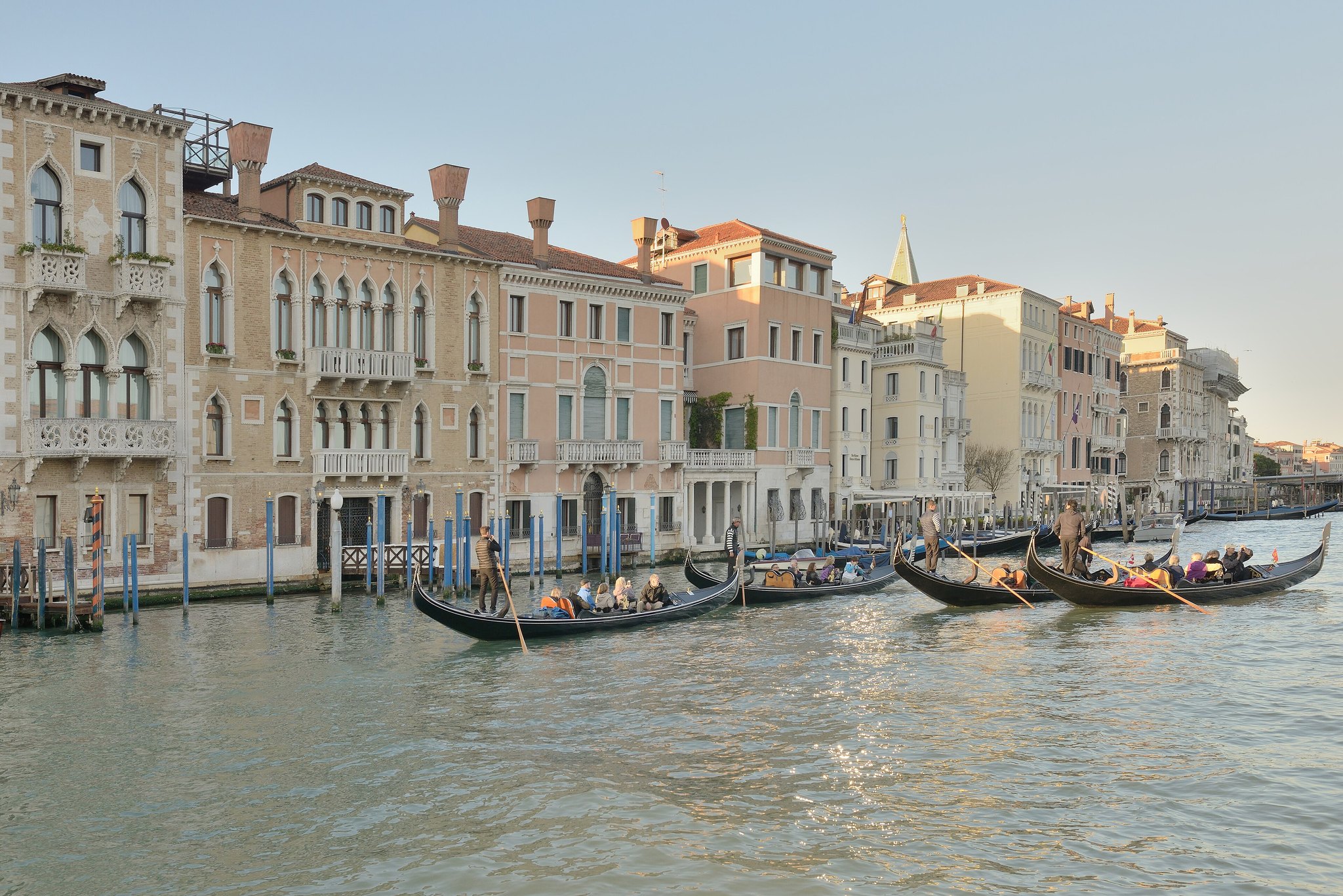 Palazzi along the Grand Canal with gondolas moored at their striped posts