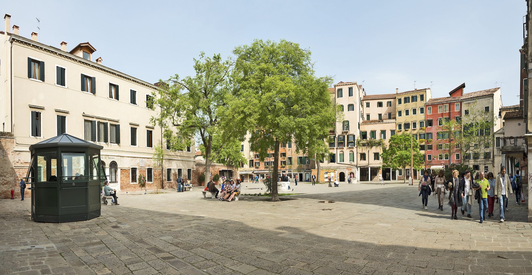 The Campo del Ghetto Nuovo seen along its length, trees in the middle and the tallest houses in Venice around it
