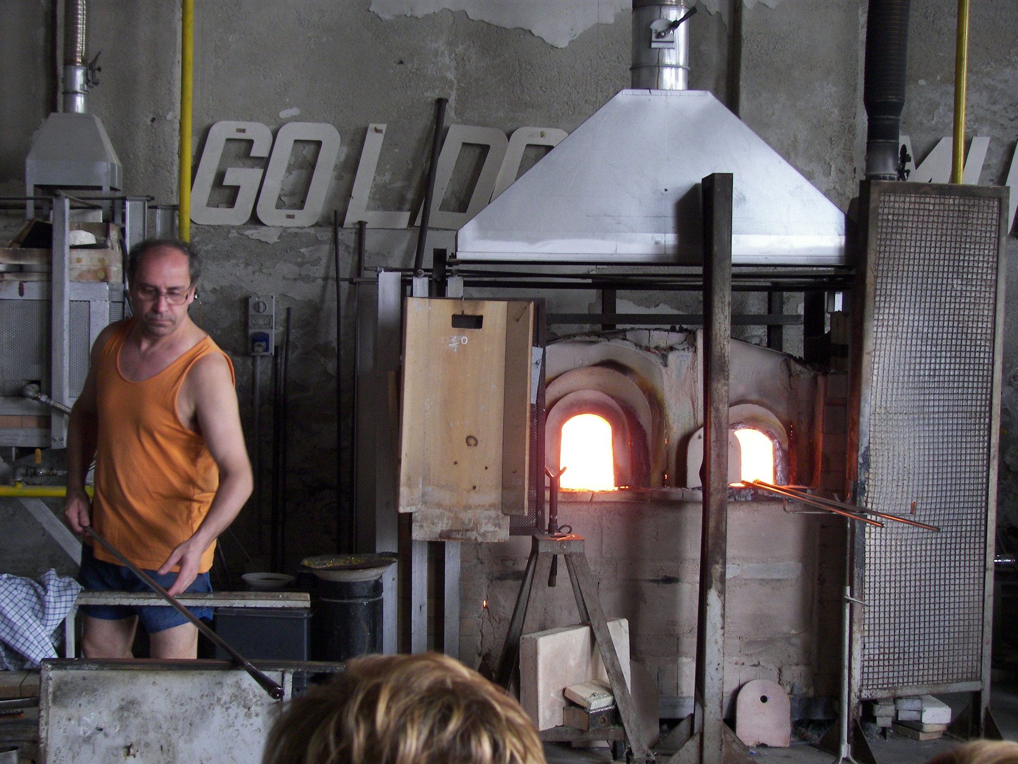 A glassblower at the furnace on Murano, gathering from the glory hole in front of an audience