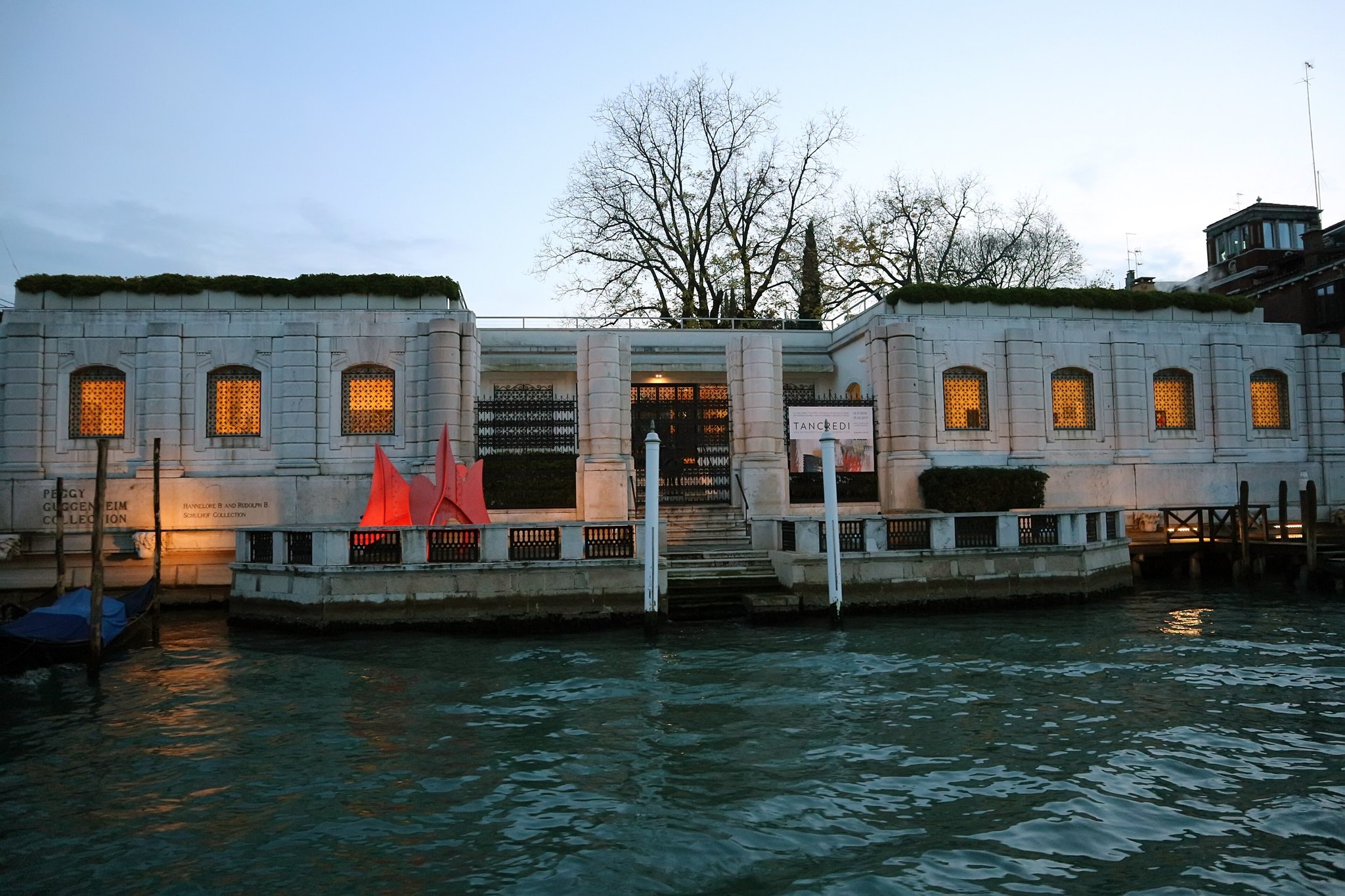 The Peggy Guggenheim Collection at dusk, its low white front along the Grand Canal with the windows lit