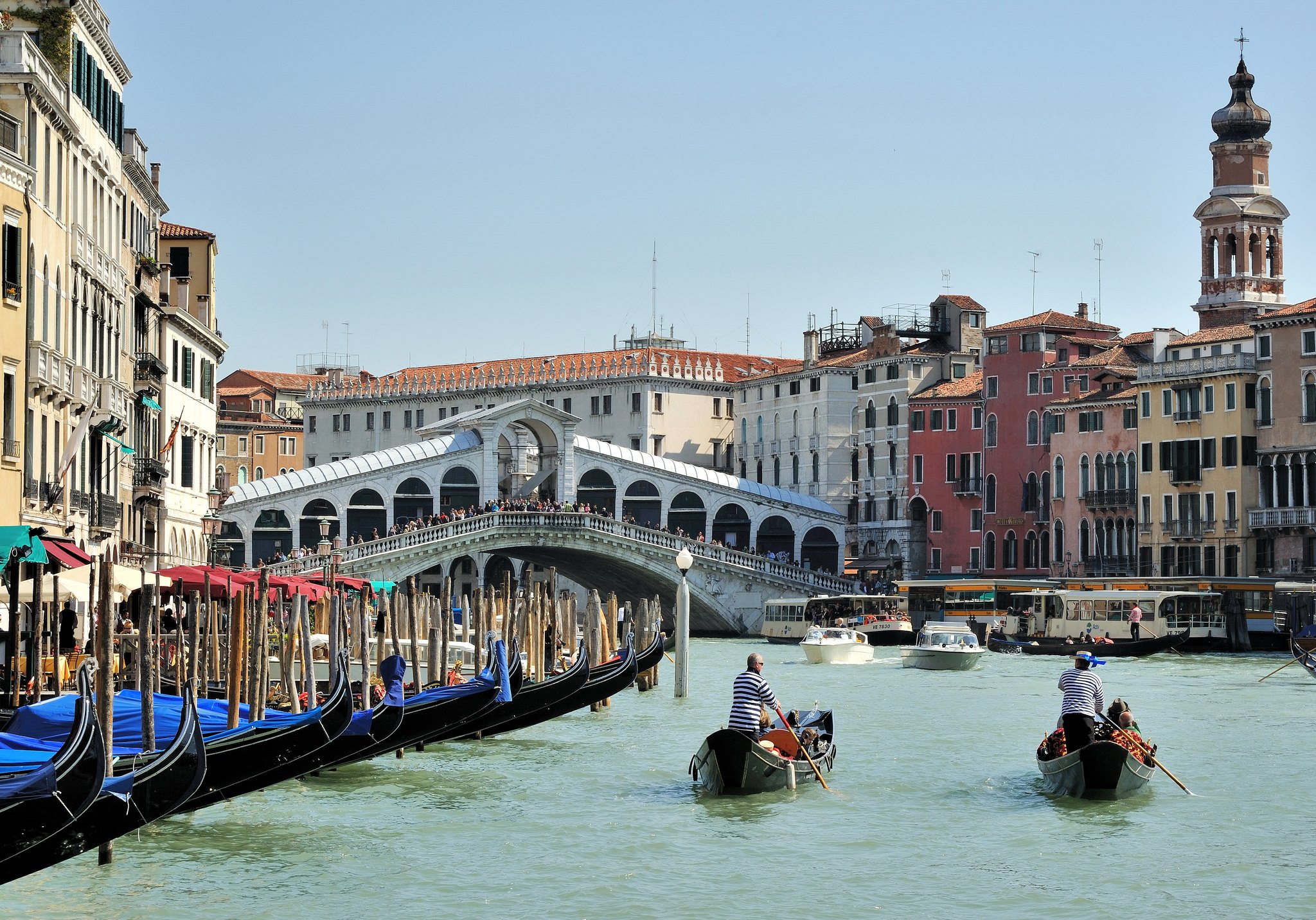 The Rialto Bridge with gondolas moored in a line along the canal in front of it