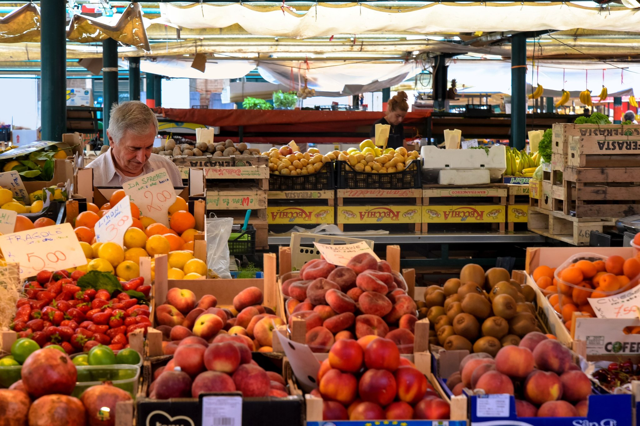 A fruit and vegetable stall at the Rialto market, boxes of berries and tomatoes with handwritten prices