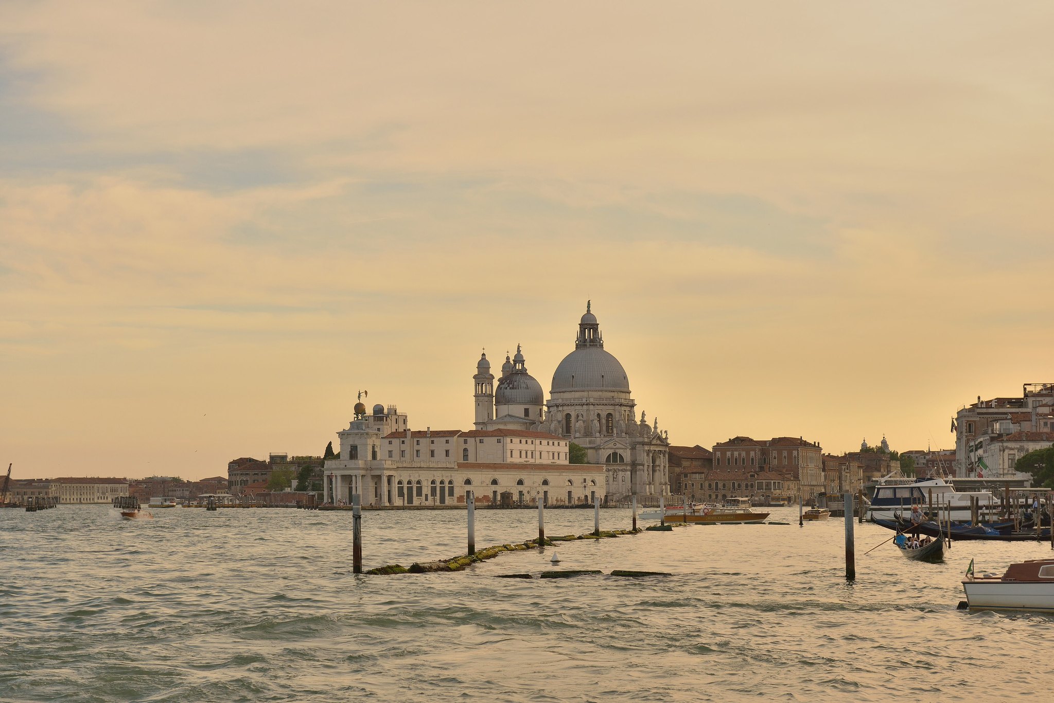 Santa Maria della Salute at sunset from across the water, the customs point beside it and mooring posts in the foreground