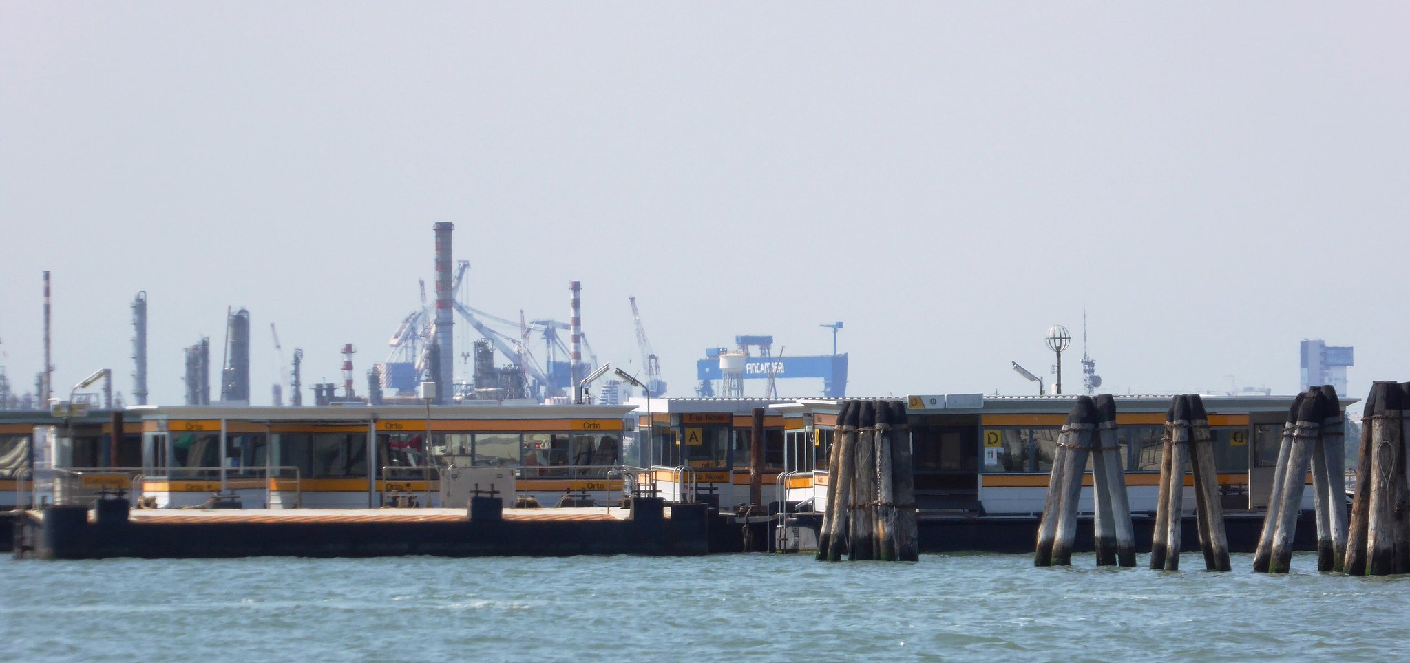 A row of vaporetto pontoons moored along a Venetian waterfront, the floating stops the waterbuses tie up to