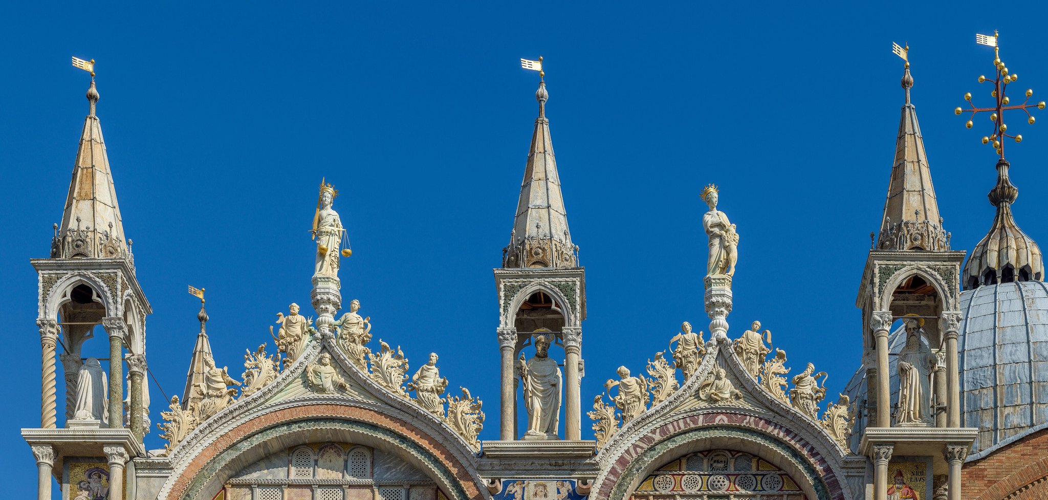 The upper south front of St Mark's, a row of crocketed Gothic gables and finials against a deep blue sky